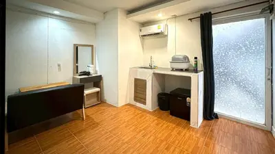 a room with a kitchen with a table and a window at Chubby5room12 in Ban Bang Phlat