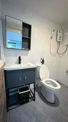 a bathroom with a toilet and a sink and a mirror at Chubby5room12 in Ban Bang Phlat
