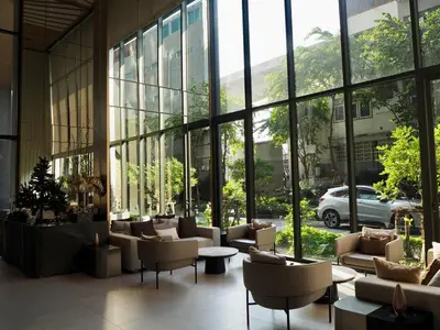 a lobby with couches and chairs in a building with windows at The Crest Park Residences Monthly Rent only #2BR Apartment at Chatuchak #MrtBts in Bangkok
