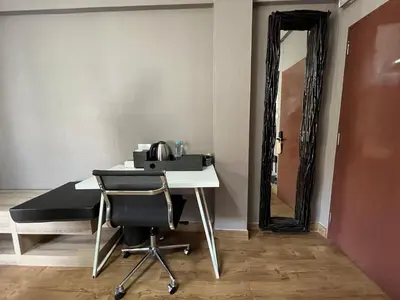 a table with a chair and a mirror in a room at BT fifty in Bangkok