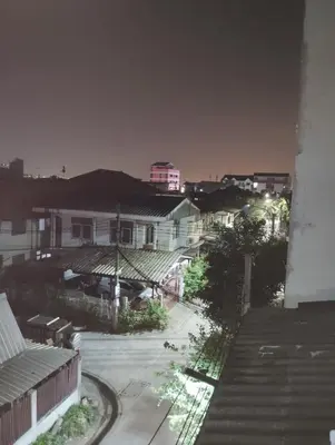 a view of a city at night with buildings at 14 Hostel DMK airport in Bang Khen