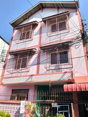 a pink and white building with barred windows at 14 Hostel DMK airport in Bang Khen
