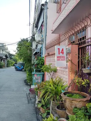 a sign on the side of a building with plants at 14 Hostel DMK airport in Bang Khen
