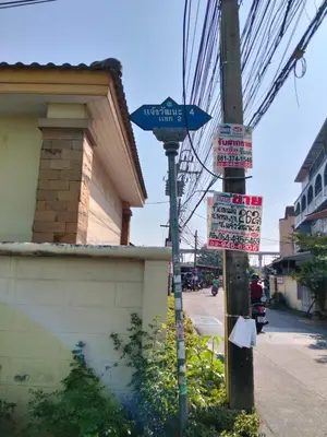 a street sign on a pole on a city street at 14 Hostel DMK airport in Bang Khen