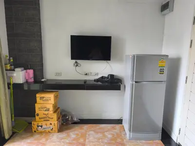 a kitchen with a refrigerator and a tv on a wall at mint apartment in Sathani Bang Su