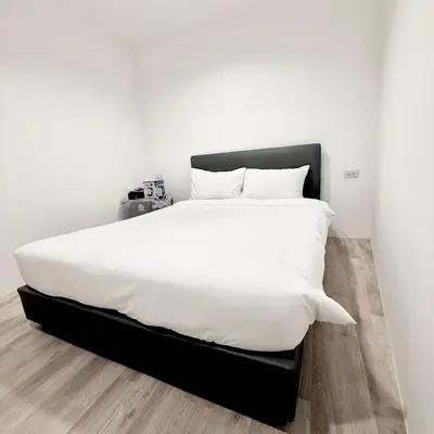 a large white bed with white sheets and pillows at z Rest Inn Silom - เรสท์ อินน์ สีลม in Bang Rak