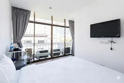 a bedroom with a bed and a flat screen tv at z Rest Inn Silom - เรสท์ อินน์ สีลม in Bang Rak
