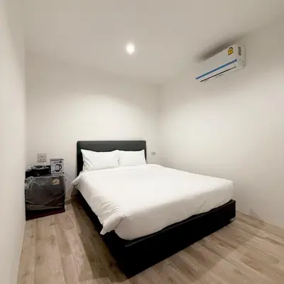 a bedroom with a large white bed with a white blanket at XX Rest Inn Silom Bangkok in Bang Rak