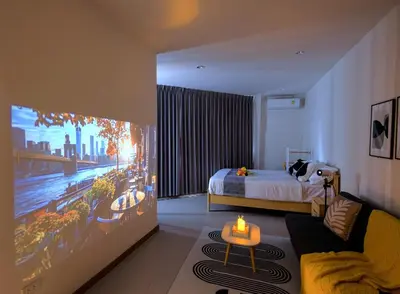 a hotel room with a bed and a tv at Common Living Bangkok in Bangkok