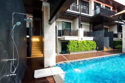 a bathroom with a swimming pool next to a building at Yotaka Bangkok Hotel in Bangkok