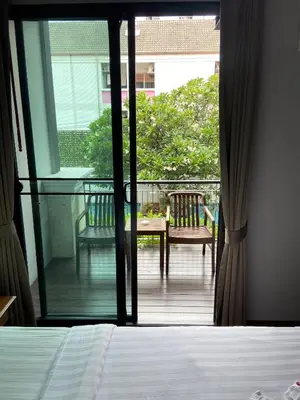 a bedroom with a view of a balcony with a bed at Yotaka Bangkok Hotel in Bangkok