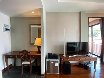 a living room with a desk and a television at Yotaka Bangkok Hotel in Bangkok