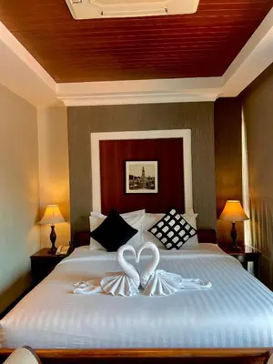 a bedroom with a bed with two white hearts on it at Yotaka Bangkok Hotel in Bangkok