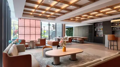 a lobby with a waiting area with tables and chairs at Leston Hotel in Bangkok