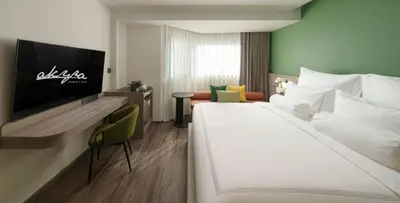 a hotel room with a bed and a tv at The Akyra Bangkok 11 in Bangkok