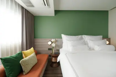 a bedroom with a bed and a couch at The Akyra Bangkok 11 in Bangkok