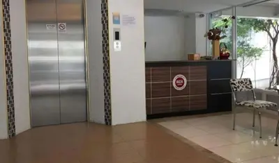 an empty lobby with a metal elevator and a chair at Grandview Ladprao Hotel in Bangkok
