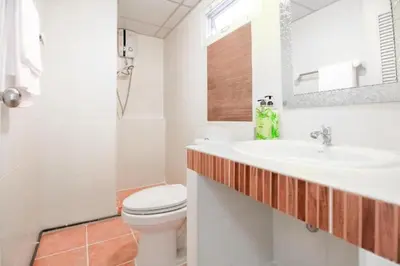 a bathroom with a sink and a toilet at Grandview Ladprao Hotel in Bangkok