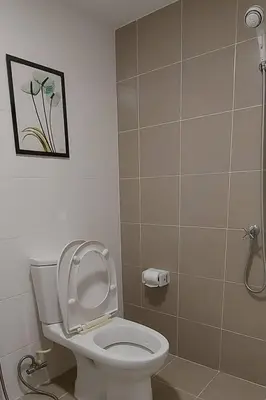 a bathroom with a toilet and a picture on the wall at Cosy Preuksa House 120 in Bang Yai