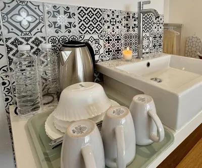 a kitchen counter with a sink and a tea set at Chatuchak Haus in Bangkok