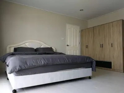 a bedroom with a large bed and wooden cabinets at BKK 2 BR apt near Sathon ICONSIAM firework view in Bangkok