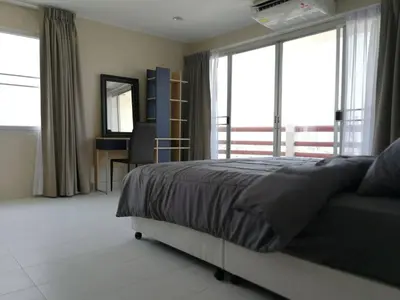 a bedroom with a bed and a desk and windows at BKK 2 BR apt near Sathon ICONSIAM firework view in Bangkok