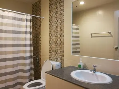 a bathroom with a sink and a toilet and a mirror at BKK 2 BR apt near Sathon ICONSIAM firework view in Bangkok