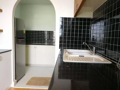 a kitchen with a sink in a black tiled wall at BKK 2 BR apt near Sathon ICONSIAM firework view in Bangkok
