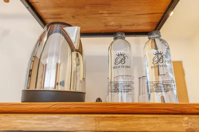 three glass bottles sitting on top of a shelf at Believeinn in Bangkok