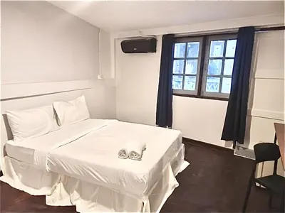 a bedroom with a white bed with a pair of engagement rings at xx zNap Yaowarat MRT วัดมังกร ใกล้สถานี 100 เมตร in Samphanthawong