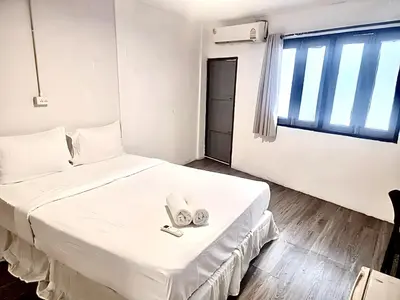 a bedroom with a large white bed with two slippers at xx zNap Yaowarat MRT วัดมังกร ใกล้สถานี 100 เมตร in Samphanthawong