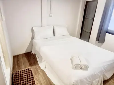 a bedroom with two beds with white sheets and slippers at xx zNap Yaowarat MRT วัดมังกร ใกล้สถานี 100 เมตร in Samphanthawong