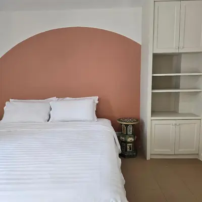 a bedroom with a white bed and a shelf at Bangkok Duplex Silom No 6 in Bangkok
