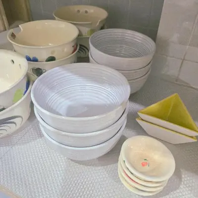 a group of white plates and bowls on a counter at Bangkok Duplex Silom No 6 in Bangkok