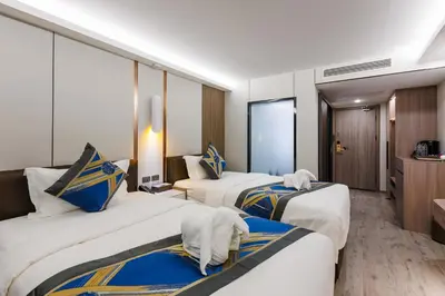 a hotel room with three beds and a bathroom at Maritztel Bangkok Hotel in Ban Bang Toei (1)
