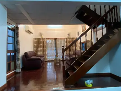a living room with two chairs and a staircase at Beautiful 2 story newly renovated bungalow house in Amphoe Phra Khanong