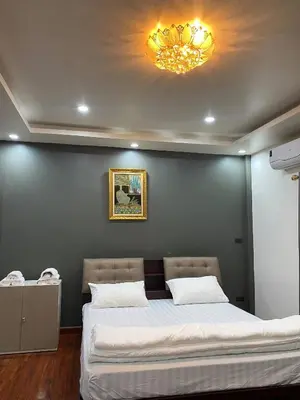 a bedroom with a large bed and a chandelier at Beautiful 2 story newly renovated bungalow house in Amphoe Phra Khanong