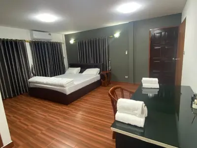 a bedroom with a bed and a desk and a table at Beautiful 2 story newly renovated bungalow house in Amphoe Phra Khanong