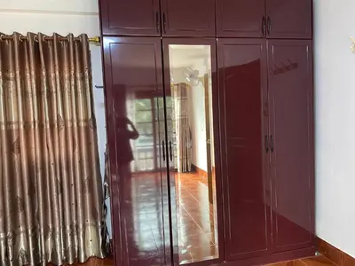 a brown cabinet with a mirror in a room at Beautiful 2 story newly renovated bungalow house in Amphoe Phra Khanong