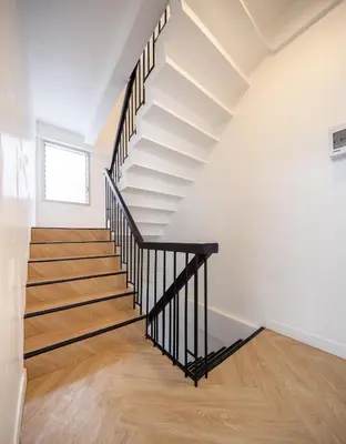 a staircase in a house with white walls and wooden floors at Luxe apartments in Pratunam