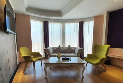a living room with a couch and two chairs and a table at The Bazaar Hotel Bangkok - MRT Lat Phrao Ratchadapisek in Bangkok