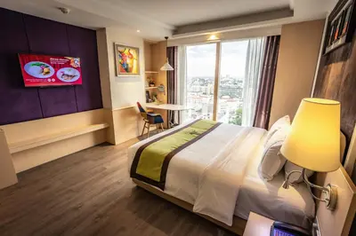 a hotel room with a large bed and a window at The Bazaar Hotel Bangkok - MRT Lat Phrao Ratchadapisek in Bangkok