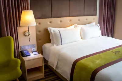 a hotel room with a bed and a lamp and a chair at The Bazaar Hotel Bangkok - MRT Lat Phrao Ratchadapisek in Bangkok