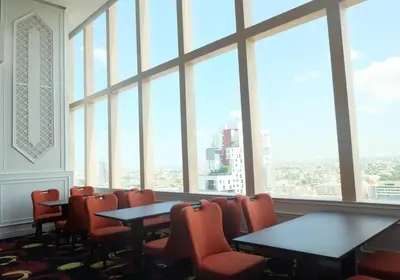 a conference room with tables and chairs and large windows at The Bazaar Hotel Bangkok - MRT Lat Phrao Ratchadapisek in Bangkok