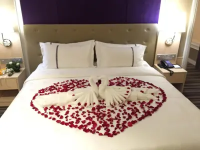 a bed with a heart made out of roses at The Bazaar Hotel Bangkok - MRT Lat Phrao Ratchadapisek in Bangkok
