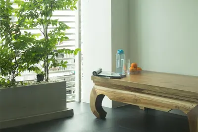 a room with a wooden table and two potted plants at Thanabhumi in Bangkok