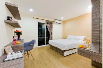 a hotel room with a bed and a desk with a computer at Thanabhumi in Bangkok