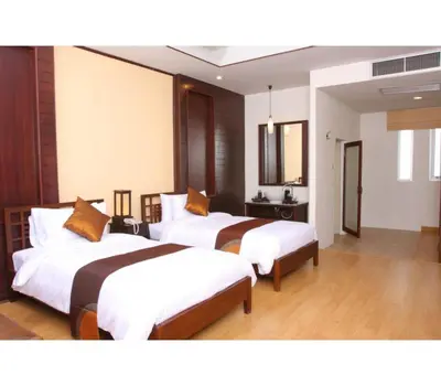 a hotel room with two beds in a room at Palette Bangkok Natural Resort and Spa in Bangkok