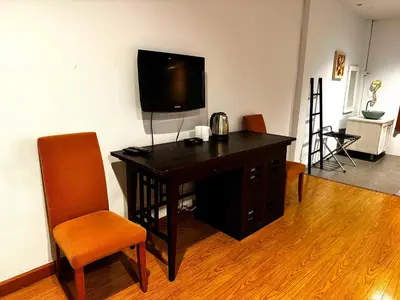 a room with a desk with a television and a chair at Palette Bangkok Natural Resort and Spa in Bangkok