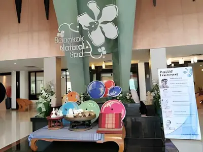 a shopping mall with a table with a flower on it at Palette Bangkok Natural Resort and Spa in Bangkok